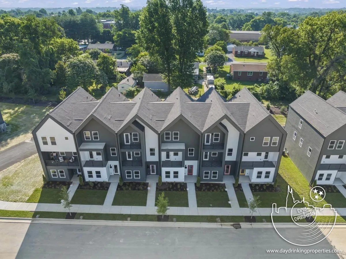 A welcoming exterior shot of modern townhomes with landscaped front yards and neatly paved sidewalks. The communal atmosphere is suggested by the inviting outdoor space—ideal for group gatherings before or after a night on the town.